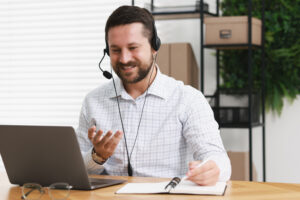 interpreter in headset taking notes while having video chat via